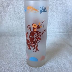 Tall drinking glass w/ monkey and tiger design.